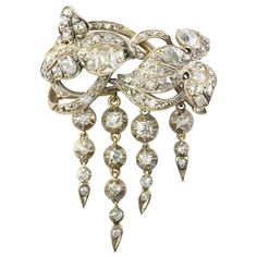 A mid-19th Century diamond brooch, designed as a miniature corsage ornament, with entwined scrolled leaves, suspending four foliate drops, all set throughout with old brilliant- and oval mixed-cut diamonds, estimated to weigh a total of 4.5 carats, all set in silver to a yellow gold mount, the drop diamonds set in cut-down silver collets, circa 1850, measuring approximately 5x3.5cm, gross weight 13 grams. This antique brooch is in very good condition for its age. Unmarked, tested as 9ct gold and Vintage Jewellery Rings, Pendant Watches, Antique Brooches, Diamond Brooch, Jewellery Shop, Antique Diamond, Victorian Jewelry, Silver Brooch, Fantasy Jewelry