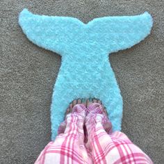 someone is standing on the floor with their feet in front of a blue teddy bear