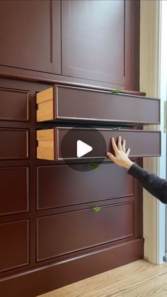 a woman is reaching for the drawer on a dresser