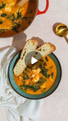 a bowl of soup with bread on the side