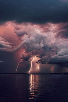 a storm is coming over the water and it appears to be lightning striking in the sky