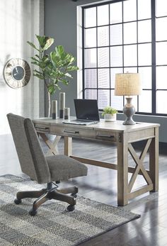 a desk with a laptop on it in front of a window and a plant next to it