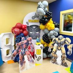 balloons and decorations are arranged in the shape of an iron man, transformer, and bumblehead