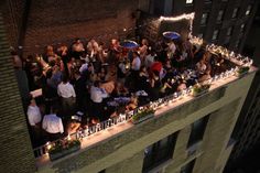 a group of people standing on top of a building next to each other at night