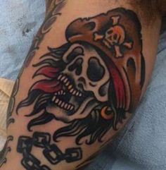 a man with a pirate skull tattoo on his arm