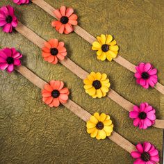 colorful flowers are tied to burlocks on a green cloth with twine around them