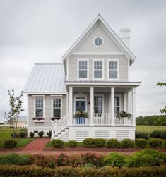 a white house sitting on top of a lush green field