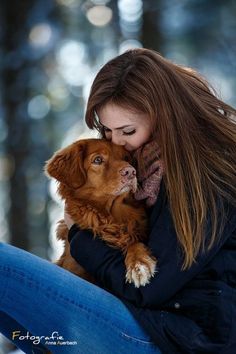 a woman holding a brown dog in her arms