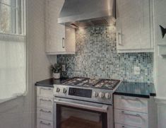 a stove top oven sitting inside of a kitchen next to a wall mounted range hood