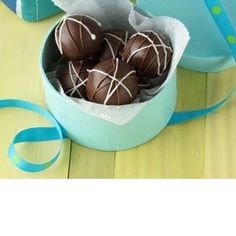 chocolate truffles in a blue box on a wooden table with a ribbon around it