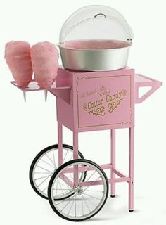 a pink cotton candy machine with two lollipops in it