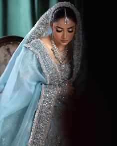 a woman in a blue and silver bridal gown