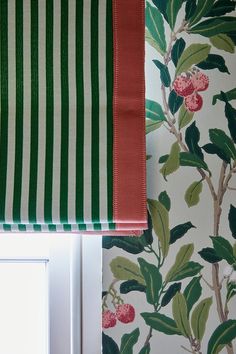 a green and white striped wallpaper with red trim next to a window in a room