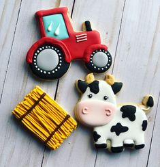 decorated cookies in the shape of farm animals, including a toy tractor and a cow