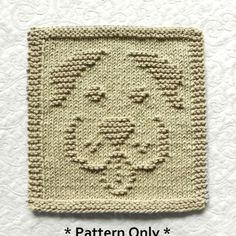 a crocheted square with a face on it