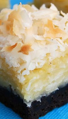 two pieces of cake sitting on top of a blue cloth covered in coconut flakes