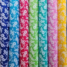 many different colors of fabric with white flowers on the bottom and blue, green, yellow, pink, purple, red