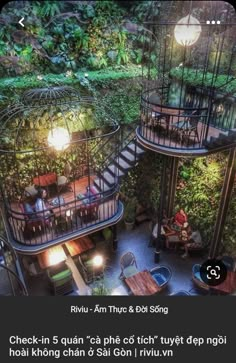 two bird cages with people sitting at tables in the middle of an outdoor cafe area