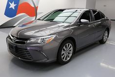 a silver toyota camry is parked in front of an american flag wallpapered background