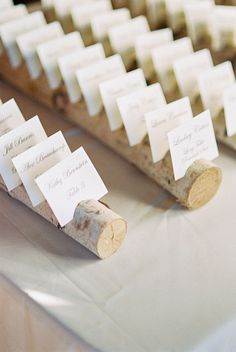 wine corks with place cards on them sitting on a table