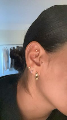 a close up of a person with ear piercings on their ears and wearing a black shirt