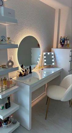 a white desk with a mirror and lights on it next to a chair in front of a shelf