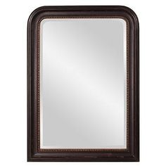 a brown framed mirror on a white wall