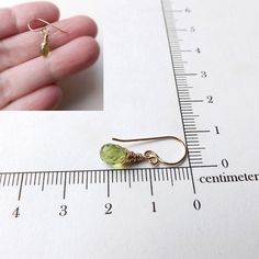 Little peridot earrings wrapped in solid 14k gold. Found some beautiful little green peridot teardrop briolettes and wrapped them in delicate 14 karat solid yellow gold wire. They hang from my signature fancy ear wires (also in 14k solid yellow gold). These little faceted peridot drops measure in at 7 x 4 mm in size. * these earrings are very petite. Please make sure you check out the measurement photo so that you get an accurate idea of the size of these little cuties. Perfect for someone who l Yellow Gold Peridot Earrings For Gift, 14k Gold Green Earrings With Ear Wire, Handmade 14k Gold Green Earrings, Green 14k Gold Hypoallergenic Earrings, Peridot Earrings In Lime Green As A Gift, Peridot Lime Green Earrings As Gift, Lime Green Peridot Earrings As Gift, Handmade Peridot Earrings As Gift, Peridot Lime Green Earrings For Gift