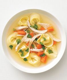 a white bowl filled with dumplings and carrots