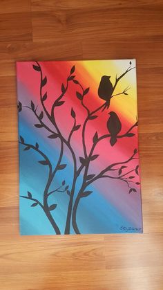 a painting of two birds sitting on a tree branch in front of a rainbow colored sky