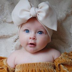 a baby with a big bow on her head