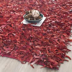 a bowl filled with food sitting on top of a red rug