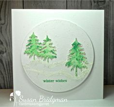 a white card with green trees on it and the words winter wishes written in black ink