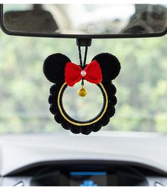 a mickey mouse keychain hanging from the side of a car's rearview mirror