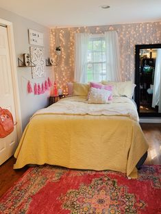 a bedroom decorated in pink and white with lights on the wall above the bed, along with an area rug