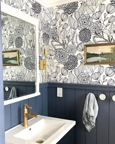 a white sink sitting under a bathroom mirror next to a wall mounted faucet