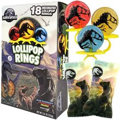 three dinosaur rings are in front of a box with the package on it's side