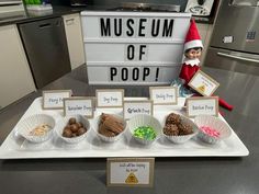 an elf is sitting in front of a museum of poop tray with candy and candies