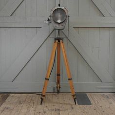 an old fashioned camera on a tripod in front of a barn door