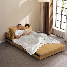 a man and child are sitting on a bed