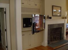 a living room with a fire place and television on the wall in front of it