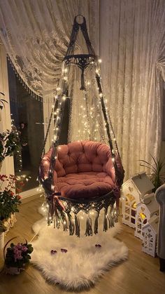 a hammock chair with lights hanging from it's sides in front of a window