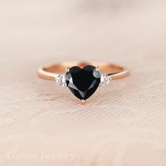 ITEM DESCRIPTION Black Simulated diamond heart engagement Ring Detail ♦ Handmade, high-quality item! ♦ Material: 14K Solid Rose Gold (can be made in Solid white/rose/yellow gold) ♦Finish: High Polishing Finish with Rhodium platting ♦ Center stone: Black Simulated Diamond (Black Cubic Zirconia) ♦ Size/Weight: Heart cut 7x7 mm ♦ Color: Black ♦ Side stones: Simulated Diamonds(7A grade super quality cubic zirconia) ♦ Cut -, Round 2.5mmx2pcs ♦ Color: D ♦Clarity: VVS1 ♦Cut Grade: Excellent ♦ Width of Black Diamond Heart Ring, Black Heart Engagement Ring, Heart-shaped 14k Rose Gold Wedding Jewelry, 14k Rose Gold Heart Jewelry For Wedding, Rose Gold Heart Ring For Promise With Prong Setting, Rose Gold Heart Cut Ring For Proposal, Rose Gold Heart Ring For Proposal, Elegant Heart-shaped Rings For Wedding Proposal, Elegant Heart-shaped Rings For Proposal