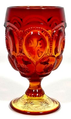 a red glass vase sitting on top of a table