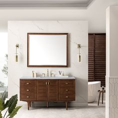 a bathroom with a large mirror and two sinks on the wall, next to a bathtub