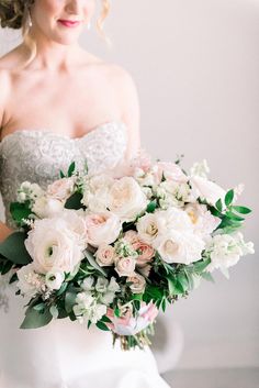 a bride holding a bouquet of white and pink flowers