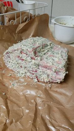 a pizza sitting on top of a piece of brown paper next to a white bowl