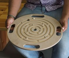 a person holding a large circular object with holes in it's center and hands