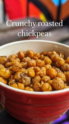 a red bowl filled with chickpeas sitting on top of a table