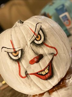 a white pumpkin with a painted face on it